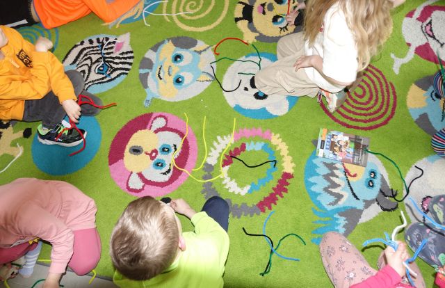 dzieci układają litery chińskie ze sznurków