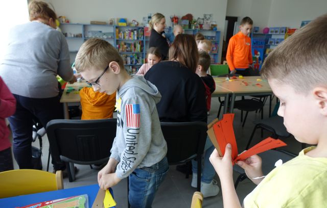 uczestniczące w warsztatach dzieci robią wachlarze