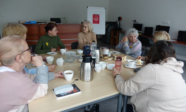 7 kobiet siedzi przy stołach