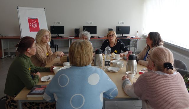 7 kobiet siedzi przy stołach