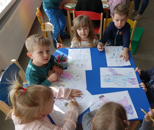 dzieci kolorują kartki z ilustracjami