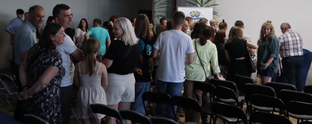 uczestnicy spotkania stojący w kolejce po autograf