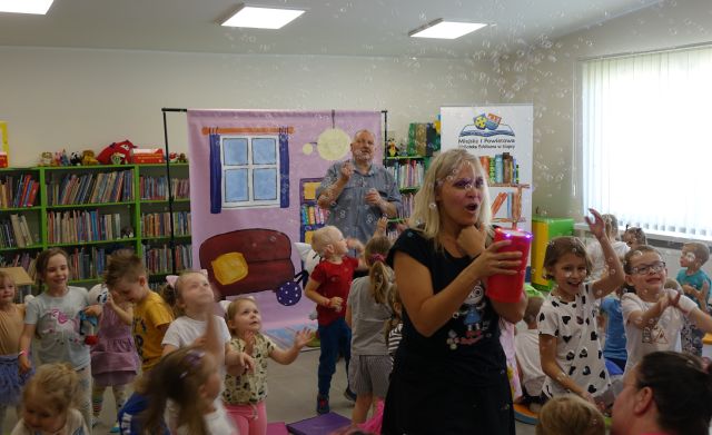 animatorka i 2 osoby dorosłe pusczają dzieciom bańki mydlane