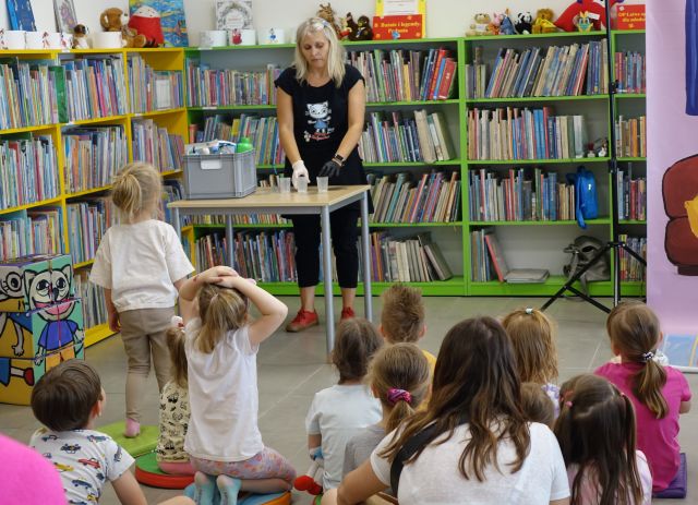 animatorka przy stole robi doświadczenia z cieczą