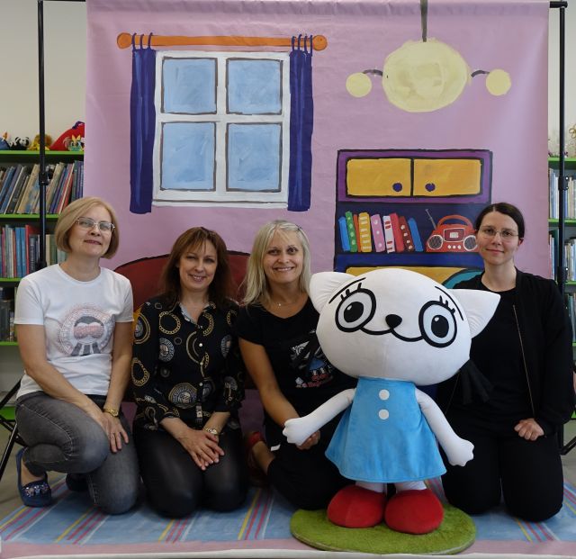 4 bibliotekarki pozują do zdjęcia z animatorką i dużą maskotką Kici Koci