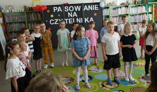 dzieci stoją na kolorowym dywanie