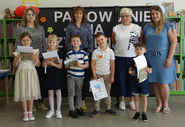 4 kobiety pozują do zdjęcia z 5 dziećmi