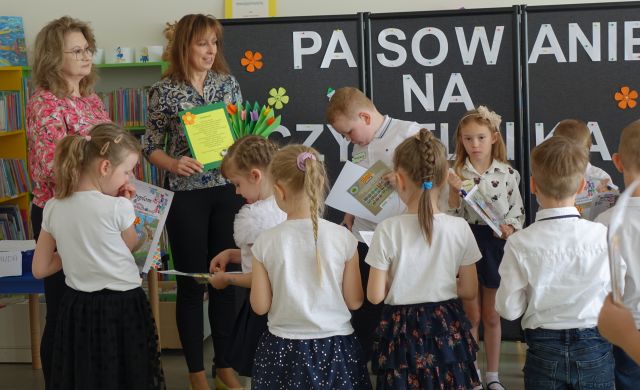 kobieta z podziękowaniem i kwiatami z papieru stoją przed dziećmi