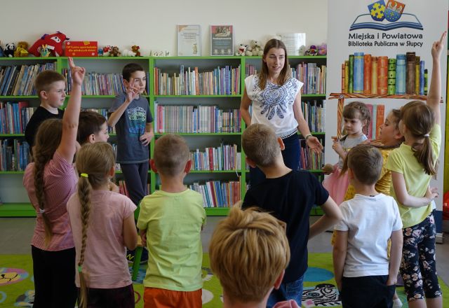 dzieci i kobieta grają w gorącego ziemniaka