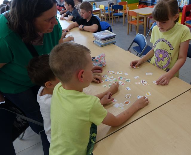 dzieci z pomocą rodziców układają w odpowiednich grupach karteczki przedstawiające warzywa i owoce, węglowodany, tłuszcze, białko