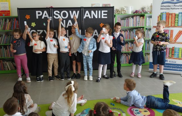 przedszkolaki stoją z podniesionymi rękami do odpowiedzi