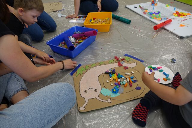 dzieci i mamy wylepiają plasteliną ślimaka