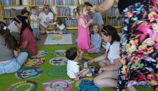 zabawa dzieci i rodziców na kolorowym dywanie