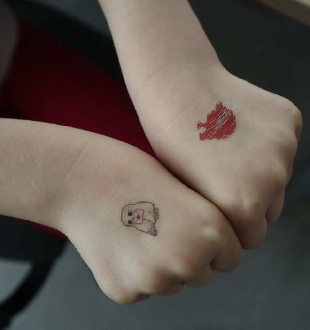 dwie dłonie z tatuarzami