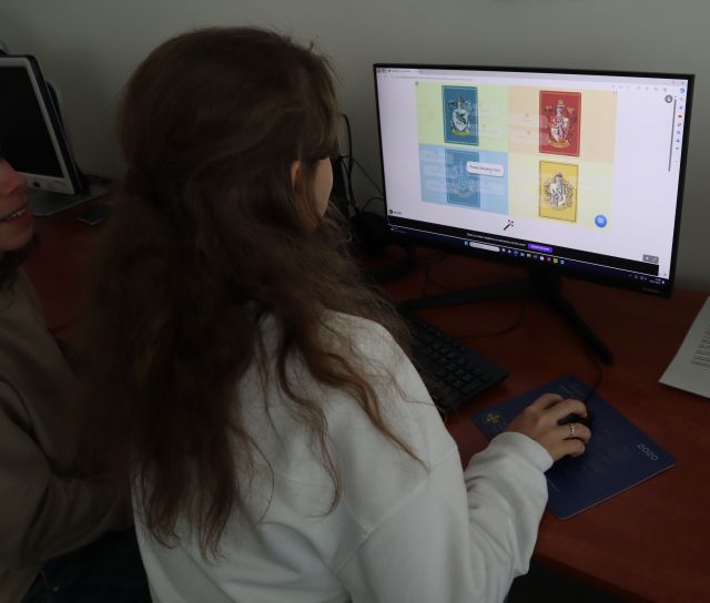 dwie dziewczyny rozwiązują test na ekranie komputera