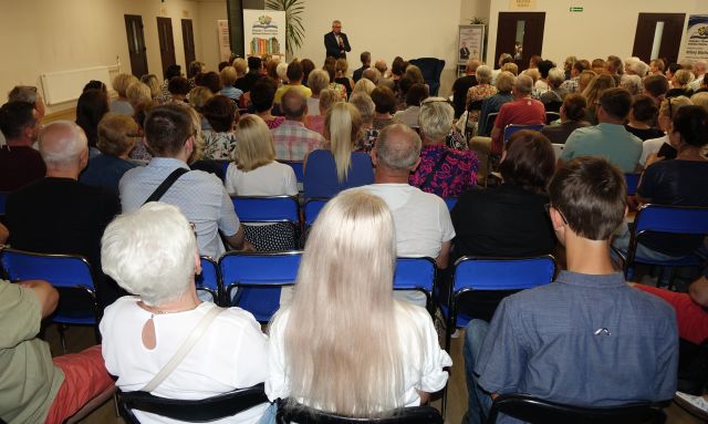 prawie 250 osób siedzących na krzesłach tyłem do aparatu