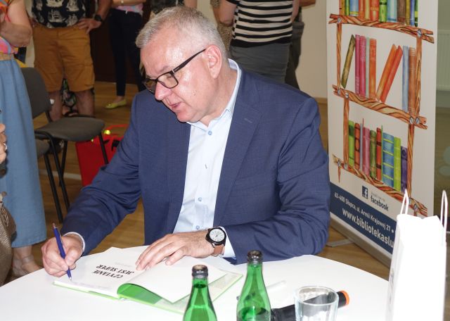 satyryk podpisuje książkę