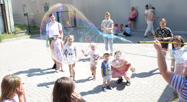 na zdjęciu bańki mydlane idzieci z rodzicami