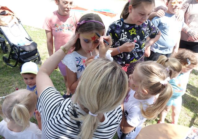 kobieta maluje dziewczynce twarz