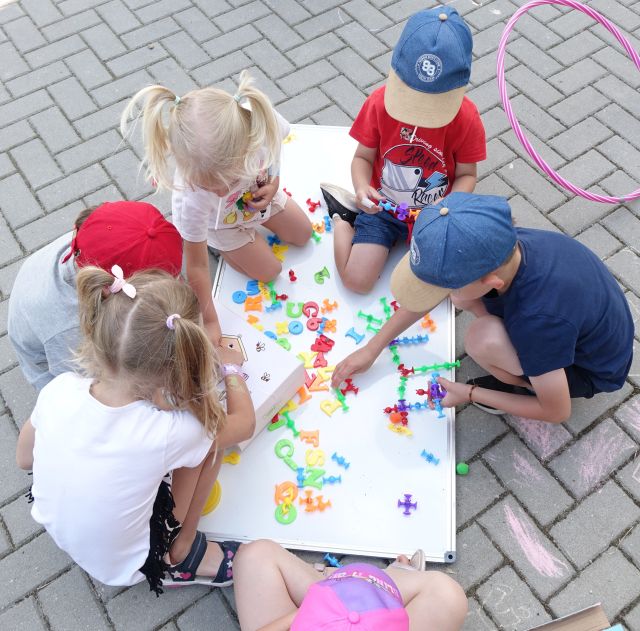 dzieci układają literki na tablicy magnetycznej