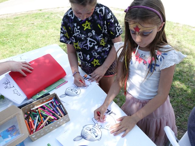 dwie dziewczynki kolorują postać z bajki Muminki