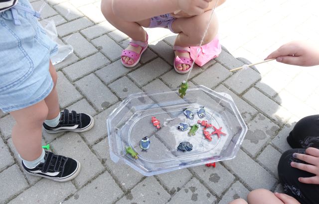 małe dzieci wyławiają plastikowe rybki z miski