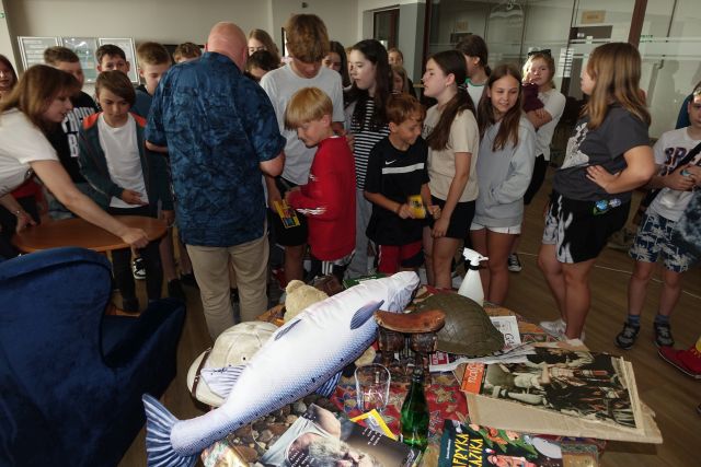 mężczyzna podpisuje dzieciom kartki