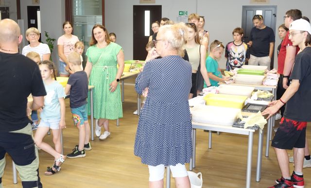 stojący przy stolikach uczestnicy warsztatów
