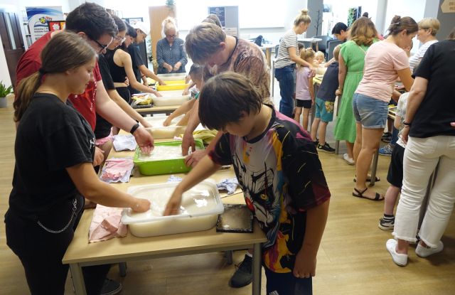 uczestnicy warsztatów robią papier czerpany