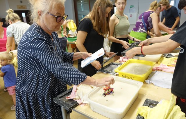 uczestnicy warsztatów robią papier