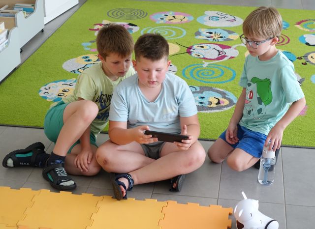 trzech chłopców steruje robotami Photon przy użyciu tabletów