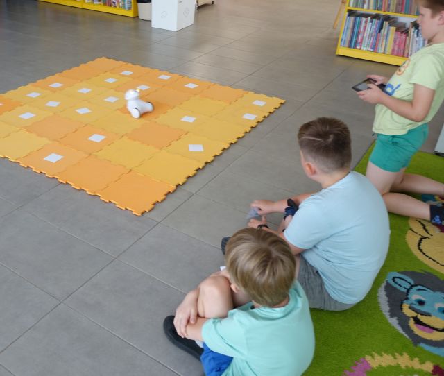 trzech chłopców steruje robotami Photon przy użyciu tabletów