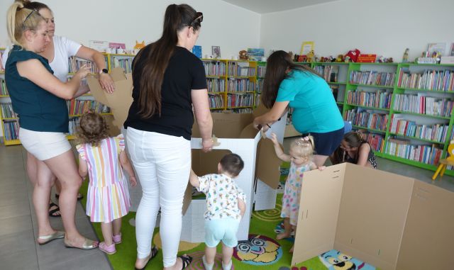 mamy z dziećmi składają domek z tektury