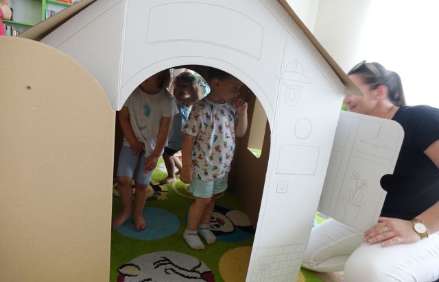 małe dzieci w kartonowym domku