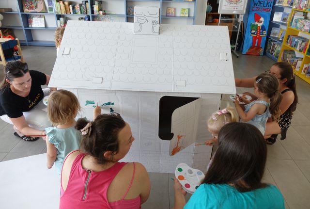 mamy z małymi dziećmi malują kartonowy domek