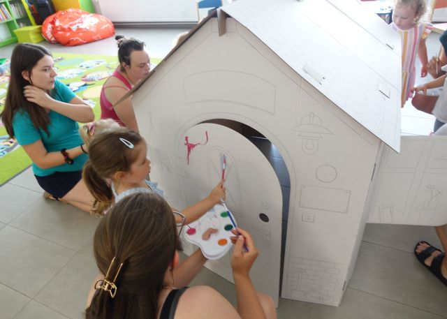 mamy z małymi dziećmi malują kartonowy domek