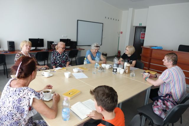 6 czestniczek DKK siedzi przy stołach, w filiżankach kawa, w tle komputery