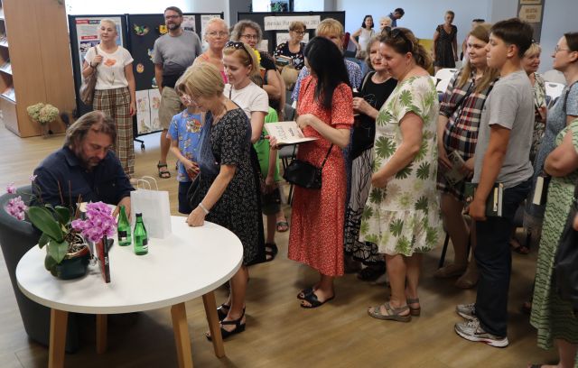 kolejka uczestników spotkania do autora po autograf