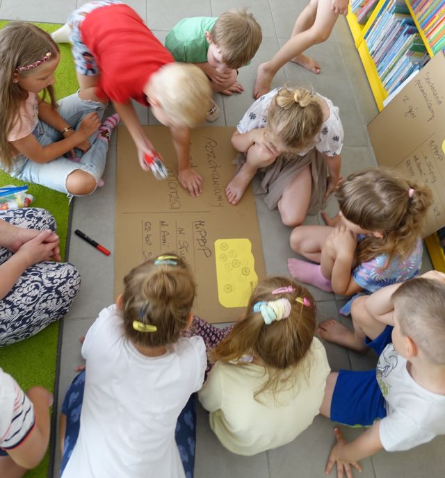 przedszkolaki na podłodze robią kartkę pocztową