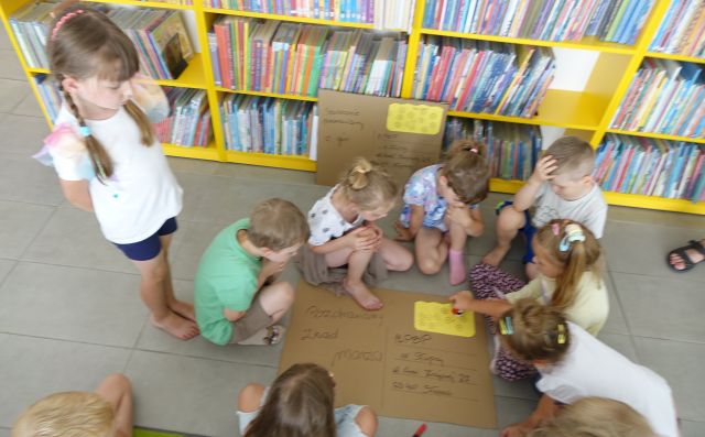 przedszkolaki naklejają wykonany przez siebie znaczek pocztowy na tekturze