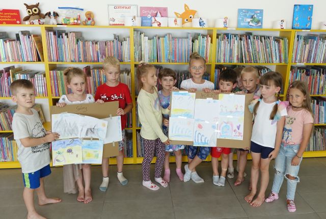 przedszkolaki prezentują wykonane przez siebie ilustracje