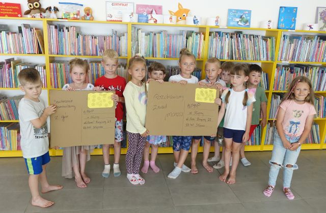 przedszkolaki prezentują wykonane przez siebie kartki pocztowe