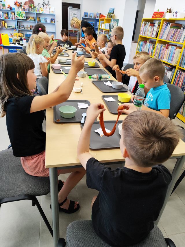 dzieci rrobią slimy, chłopiec prezentuje ciągnącego się slima