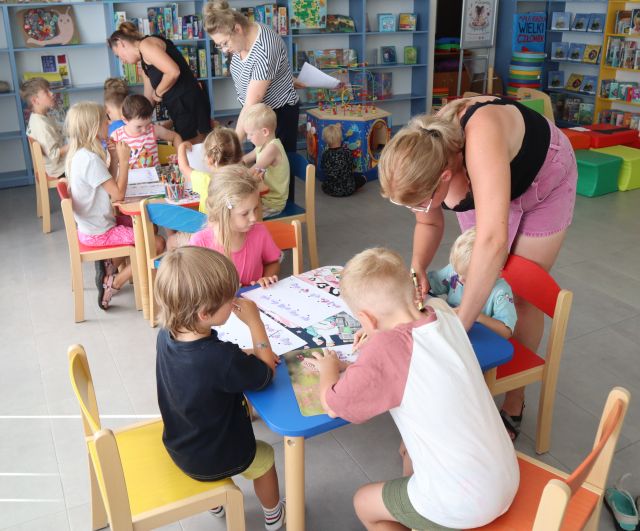 przedszkolaki przy stolikach malują