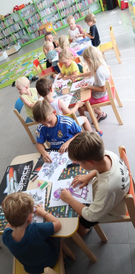 przedszkolaki przy stolikach malują