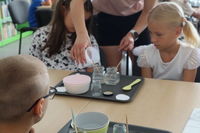 kobieta wlewająca do słoiczków płyn