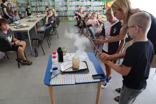 dwóch chłopców i kobieta czarują różdżkami