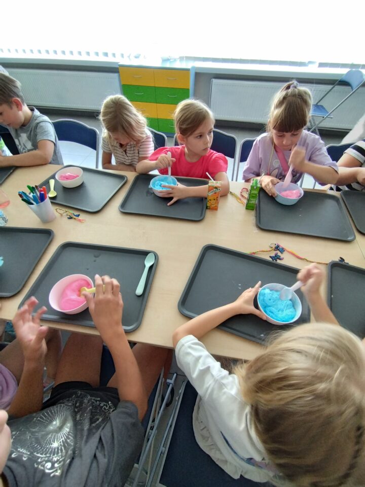dzieci mieszają kolorowe slimy w miseczkach