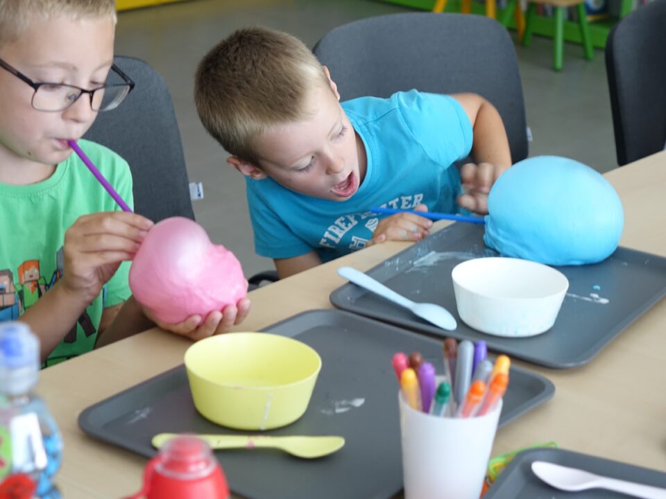 dwóch chłopców zachwyca się slimami balonami