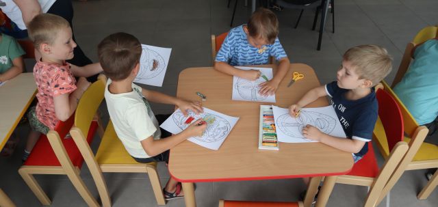 3 przedszkolakó maluje przy stolikach